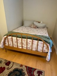 A QUEEN SIZE WOOD BED WITH BEDDING