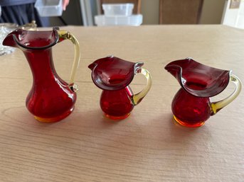 3 Red Glass Pitchers With Yellow Handles