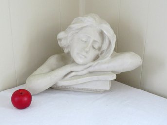 Sculpture Of A Young Woman, Tired, Resting Her Head On Her Arms Atop Books