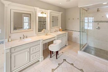 A Stone Top Double Vanity With Polished Nickel Hardware