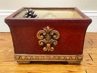 A Ceramic Planter With Pine Cones