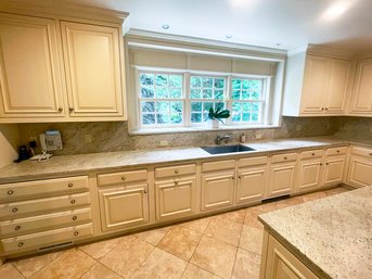 A Long Run Of Kitchen Upper And Lower Cabinets, Honed Granite Counters And Backsplash, And Sink