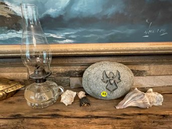 AN OIL LAMP, A CARVED ROCK, AND SEA SHELLS