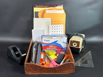 An Assortment Of Office Supplies In A Wood Letter Tray