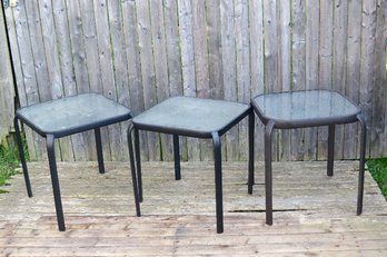 A Trio Of Square Metal Outdoor Tables With Tempered Glass Tops