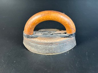 An Antique Sad Iron With A Wooden Handle, Makes A Great Doorstop!