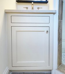 A Custom Wood Built In Vanity With Marble Counter, Sink, And Luxe Fittings