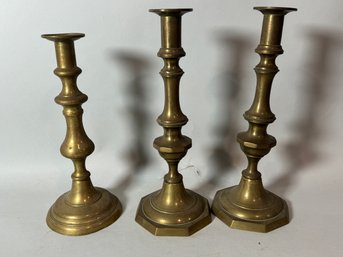 THREE 19TH CENTURY BRASS PUSH UP CANDLESTICKS