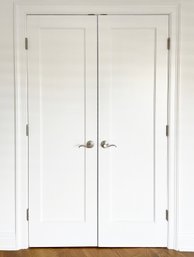 A Pair Of Paneled Wood French Doors And Interior Shelving
