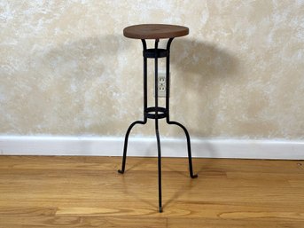 A Vintage Industrial Plant Stand With A Wooden Top & Metal Base