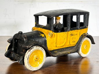 An Antique Cast Iron Yellow Cab Company Toy Car
