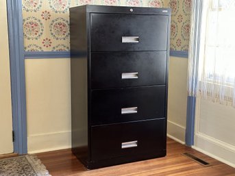 A Four-Drawer Filing Cabinet In Black Metal