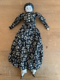 China Glazed Head Doll With Black And White Floral Dress Circa 1900's