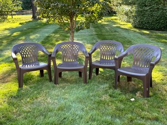 A Set Of Four Stacking All-Weather Outdoor Chairs In Brown Molded Plastic