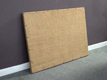 A Fabric-Covered Corkboard With Nailhead Trim