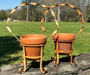 A Pair Of Wrought Iron Plant Stands And Terra Cotta Planters