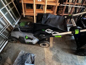 AN EGO ELECTRIC PUSH MOWER WITH BATTERY AND CHARGER