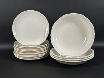 A Pairing Of Compatible Dishware In Creamy White