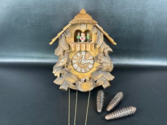 A Traditional German Cuckoo Clock With Carved Elements & Pinecone Weights