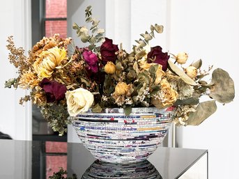 A Recycled Magazine Basket And Faux Floral