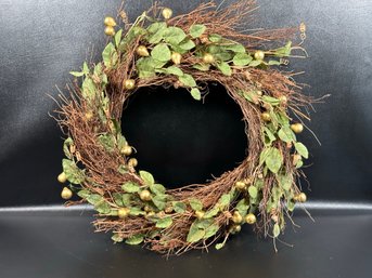 A Pretty Wreath With Greenery & Gold Berries On A Stick Form