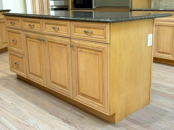 A Kitchen Island With Custom Solid Wood Cabinets And A Granite Countertop