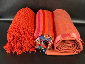 A Grouping Of Cozy Blankets In Orange Tones