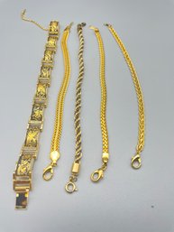 Five Gold Tone Bracelets.