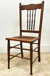 A Victorian Carved Oak Cane Seated Side Chair