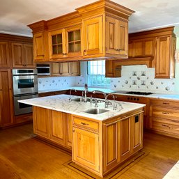 A Custom Cabinetry Island With Italian Calacatta Gold Marble Counter And Upper Storage