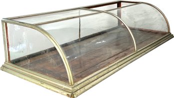 An Antique Bakery Counter Display With Curved Glass Panels