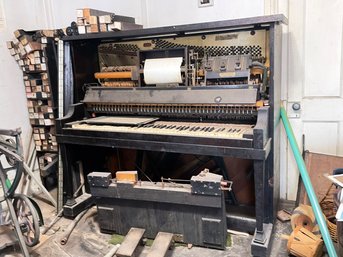 An Antique Player Piano Carcass And Piano Rolls