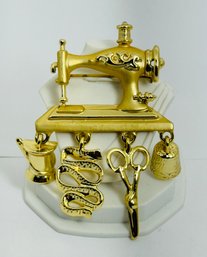 SIGNED AJC GOLD TONE SEWING MACHINE WITH DANGLING TOOLS BROOCH