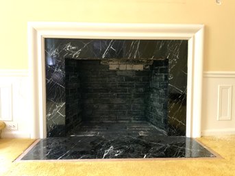 A Wood Firepalce Surround With Marble Inset And Hearthstone