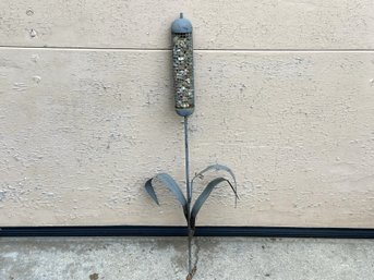 A Cattail Wire Cage Bird Feeder Filled With Pebbles