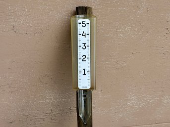 A Rain Gauge By Taylor Mounted On A Post