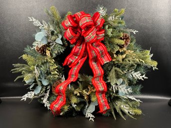 A Festive Holiday Wreath With Assorted Evergreens & Wired Plaid Ribbon