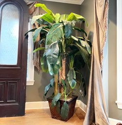 A Large Faux Banana Plant In Wood Planter