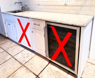 A Granite Counter, Stainless Sink With High End Fittings And Several Solid Wood Base Cabinets