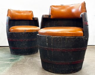 A Pair Of Vintage Whiskey Barrel Chairs With Vinyl Upholstery