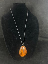 Amber Pendant Hanging On Black Cord - Stone Has Visible Objects From Nature Imbedded In It