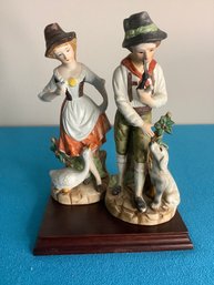 PAIR OF FIGURINES WITH ANIMALS ON BASE