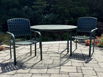 An Outdoor Dining Table With A Textured Glass Top & Two Chairs