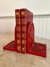 A Pair Of Red Metal Asian Bookends With 2 Leather Bound Vintage Books By Lewis Carroll