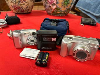 2 Nikon Cameras And A Battery Pack