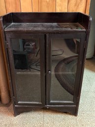 A SMALL BOOKCASE W/ GLASS DOORS
