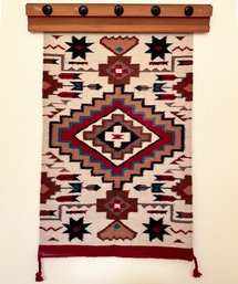 A Navajo Graphic Rug On Pine Mounting Bar