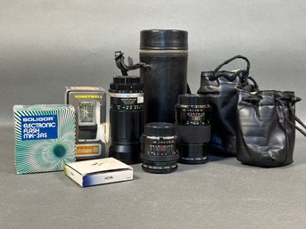 An Assortment Of Camera Accessories, Including Thee Zoom Lenses
