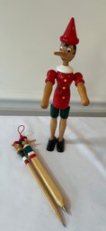 Pinnochio Figurine With Pen And Pencil