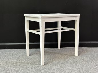 A Small Vintage Bench In White With A Caned Seat